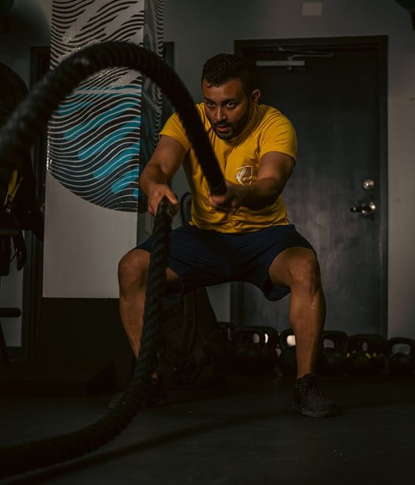 Man performing strength exercises in a dark gym setting